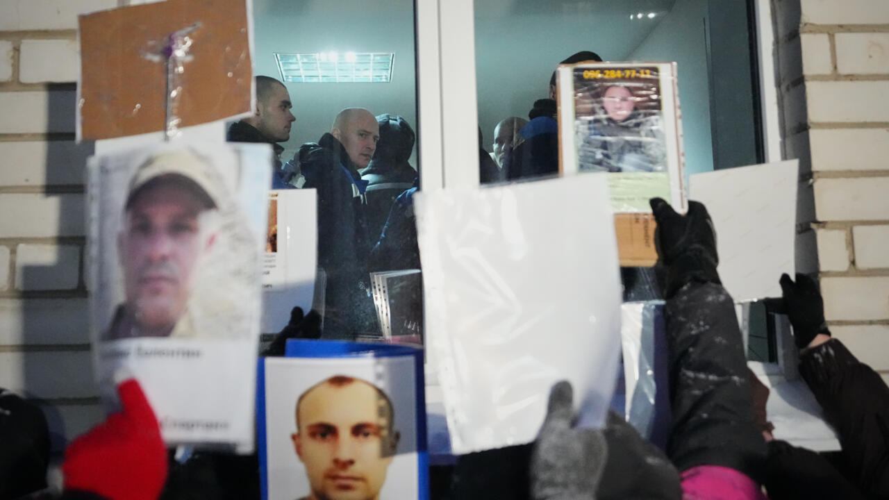 File photo of people hold photos of missing relatives during a  POW exchange between Russia and Ukraine taken in Chernyhiv region, Ukraine, February 5, 2026.