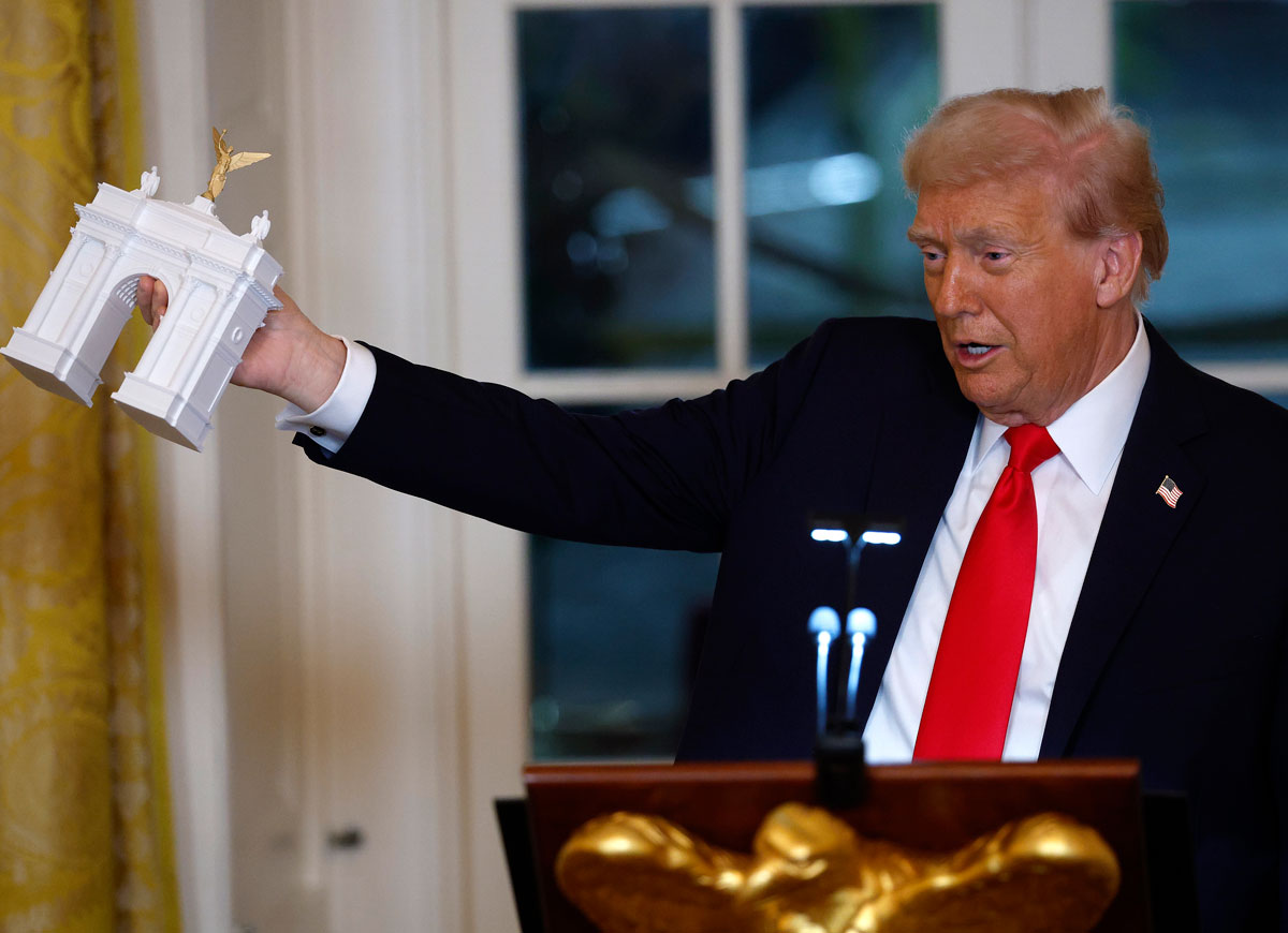 WASHINGTON, DC - OCTOBER 15: U.S. President Donald Trump holds a model of an arch as he delivers remarks during a ballroom fundraising dinner in the East Room of the White House on October 15, 2025 in Washington, DC. Trump hosted organizations and individuals for a fundraising dinner for the new $250 million ballroom addition currently under construction at the White House. (Photo by Kevin Dietsch/Getty Images)
