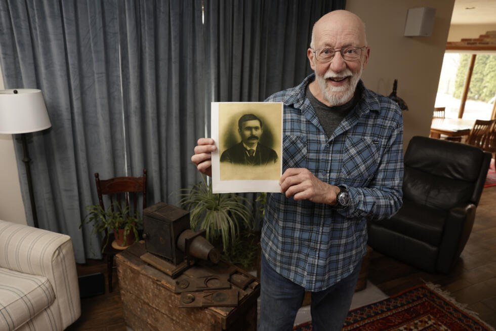 Bill McFarland holds up a photo of his great-grandfather, William DeLyle Frisbee, who left his family a cache of old silent movies