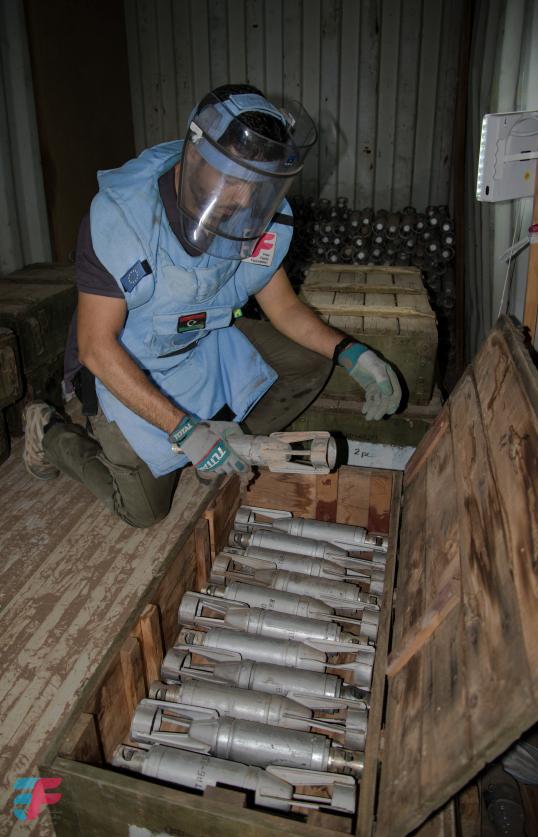 Deminer in Tripoli wearing a blue costume and helmet