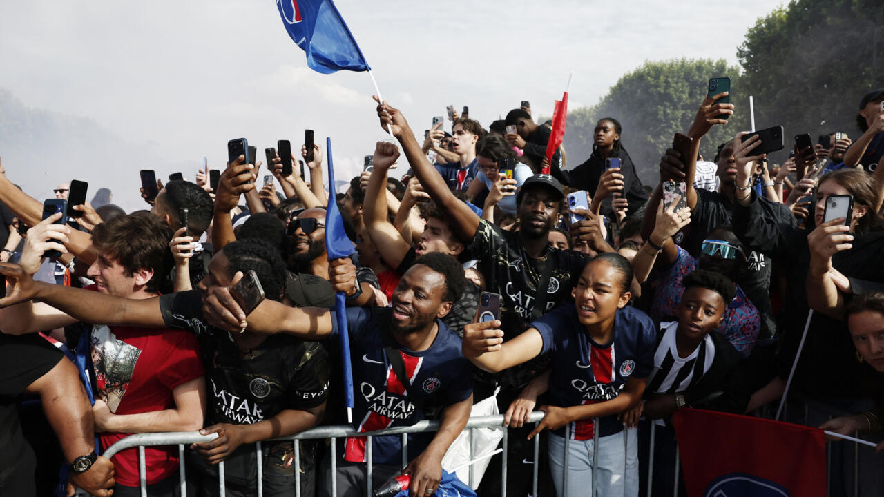 Jubilant fans look on as coach Luis Enrique and the players arrive to present the Champions League trophy at the foot of the Eiffel Tower.