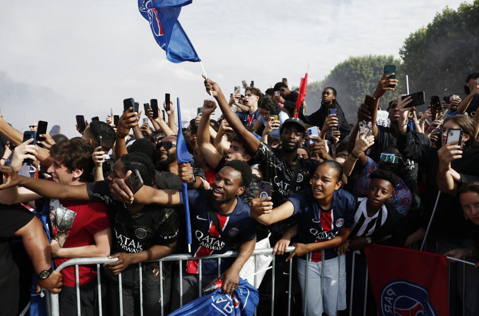 Jubilant fans look on as coach Luis Enrique and the players arrive on the stage.