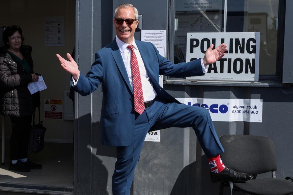 Reform UK leader Nigel Farage poses to show off his socks as he visits a polling station in Walton-on-the-Naze, eastern England on May 7, 2026.