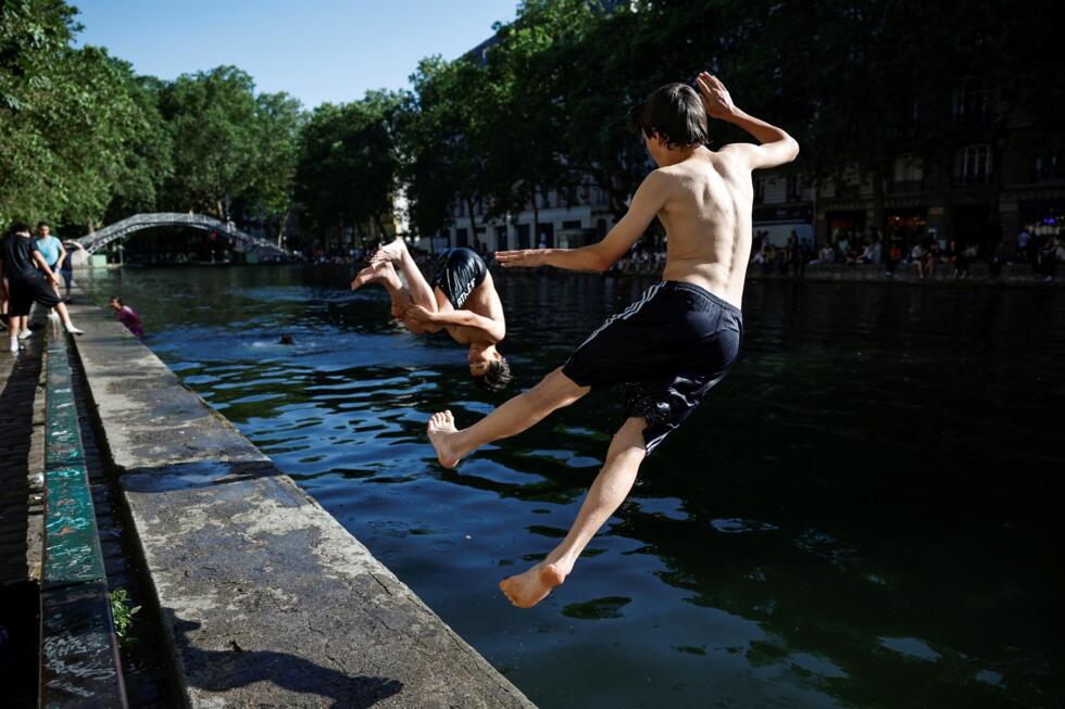 Teenagers jump into the Canal Saint-Martin to cool off during a heatwave in Paris, France, on May 26, 2026.