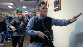 Senate security officials run after gunfire was heard along a hallway at the Philippine Senate in Pasay, May 13, 2026. 