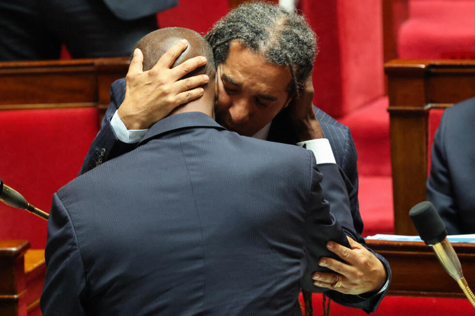 Representative Steevy Gustave(Ecologist and Social Party) hugs Representative Max Mathiasin (Liot) after the unanimous passage of his bill to abolish the Code Noir and laws relating to slavery, on May