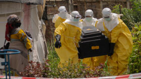 A woman cries as Red Cross workers carry the coffin of a person who died of Ebola in Rwampara, Congo, May 20, 2026.
