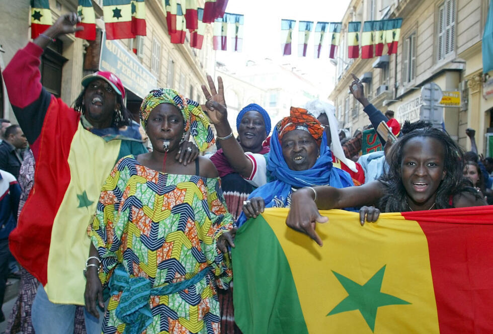 Senegalese fans celebrate their team's qualification for the knockout stages in the streets of Marseille on June 11, 2002.