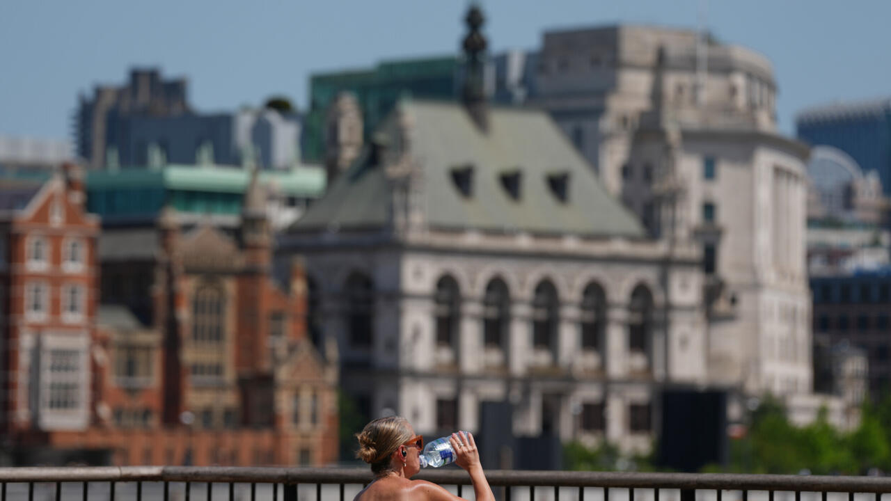 A woman takes a drink in London, as a heatwave is predicted Tuesday, June 23, 2026.