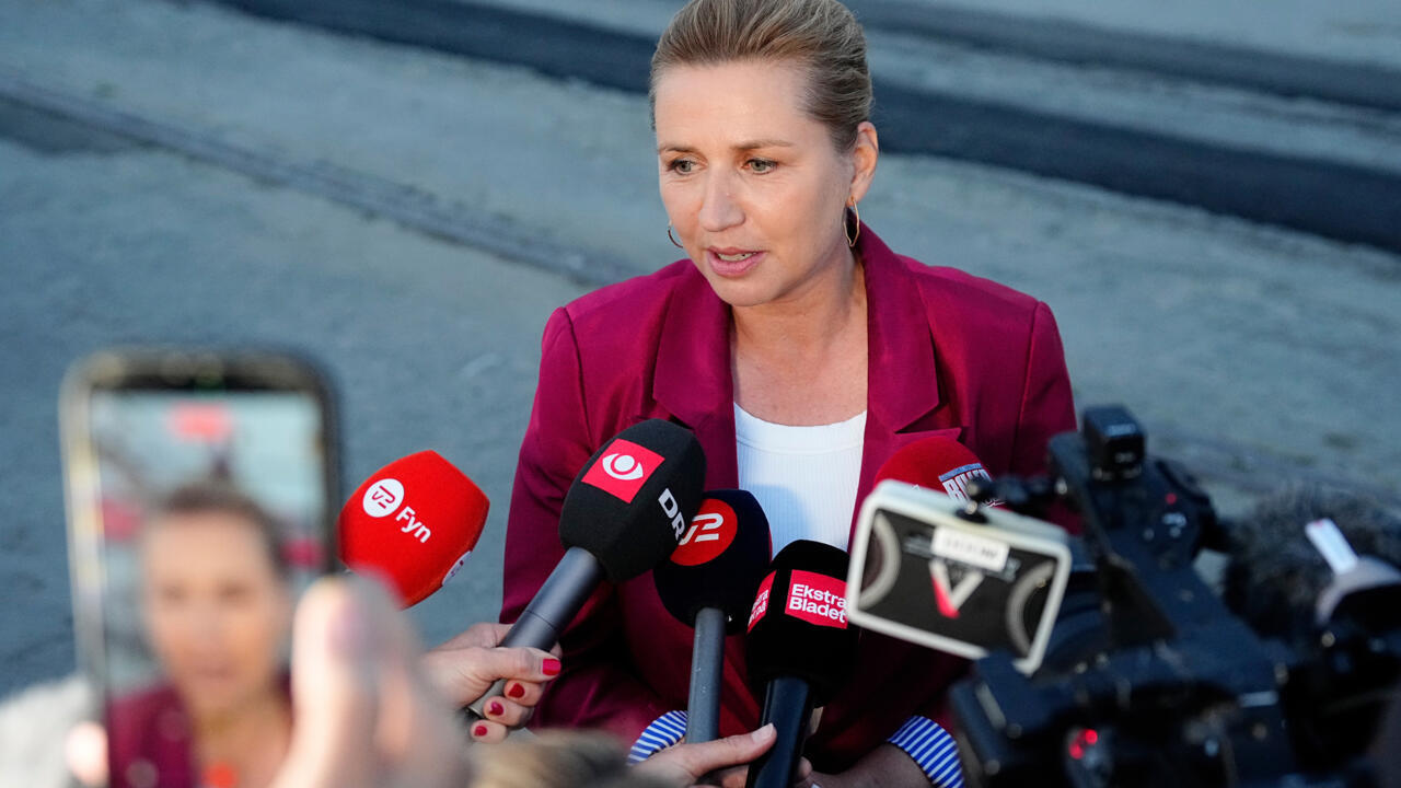Danish Prime Minister and leader of the Social Democrats Mette Frederiksen, centre, stands with party members at a rally in Copenhagen on March 24, 2026.