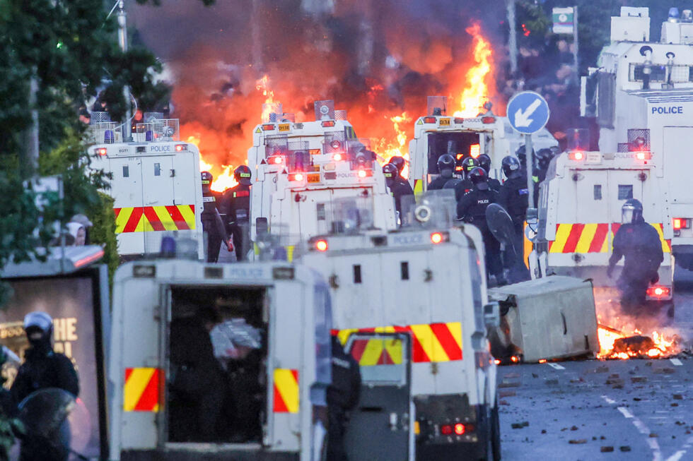 Fires rage around police vehicles as protesters clash with law enforcement in Glengormley, north of Belfast, on June 10, 2026