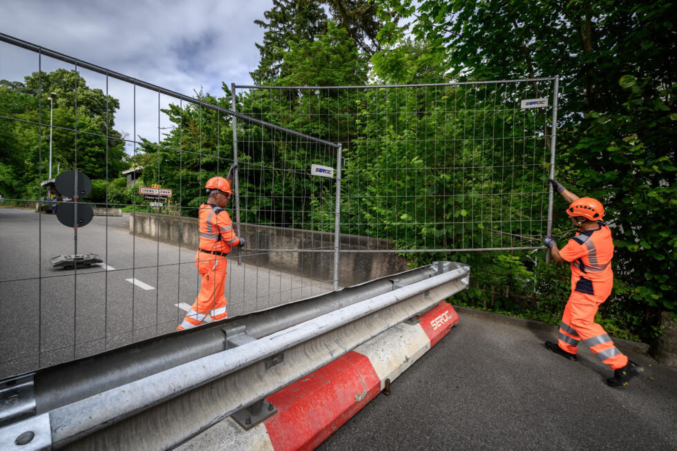 Workers have set up fences to close the border crossing between Switzerland and France in the lakeside village of Hermance