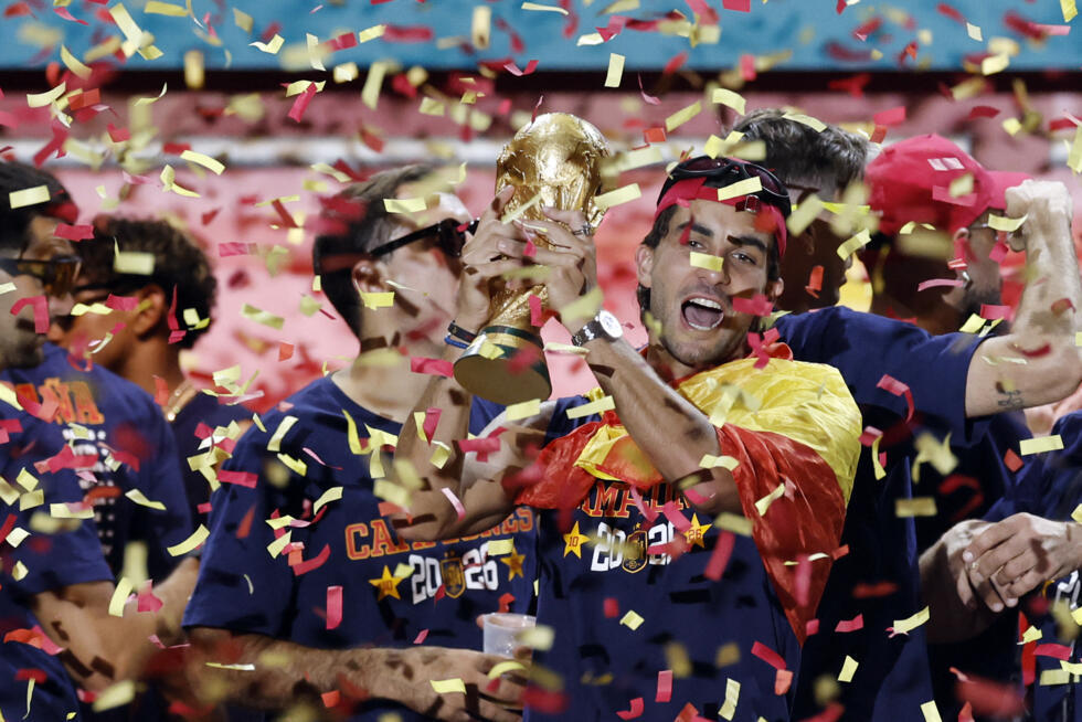 Spain's forward Ferran Torres raises the trophy as players celebrate on a stage at Cibeles Square in Madrid one day after winning their second World Cup.