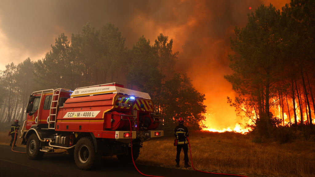 Firefighters try to extinguish fires burning trees using a wildland water truck near Le Porge, southwestern France, on July 23, 2026