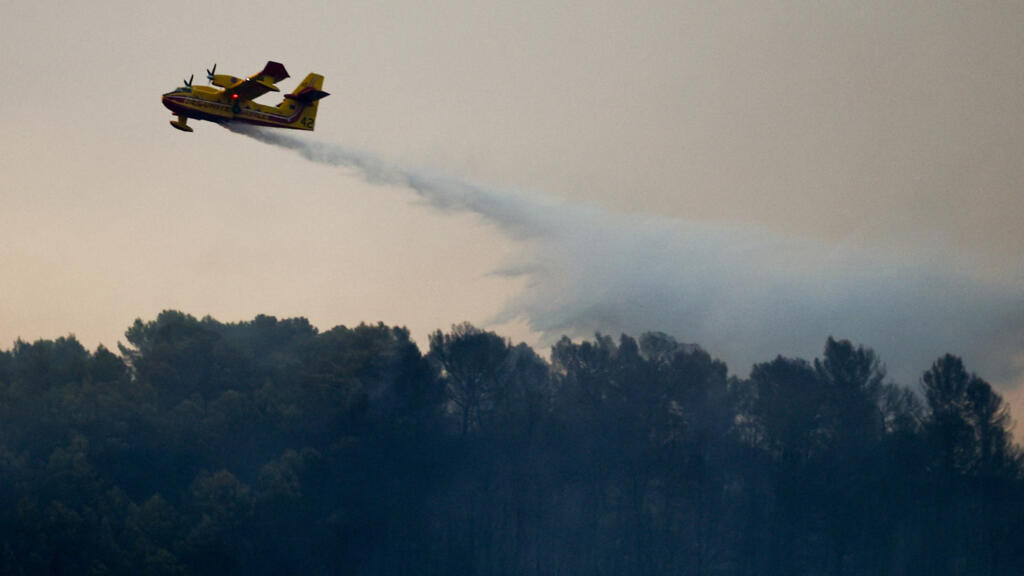 Un avion largue un produit ignifuge sur un feu de forêt entre Taradeau et Les Arcs-sur-Argens, près d'Arc-sur-Argens, dans le sud de la France, dimanche 19 juillet 2026.