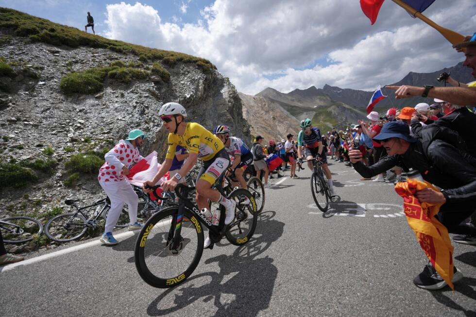 Slovenia's Tadej Pogacar, wearing the overall leader's yellow jersey, climbs the Galibier pass ahead of Belgium's Remco Evenepoel, centre, during the 20th stage of the Tour de France cycling race.