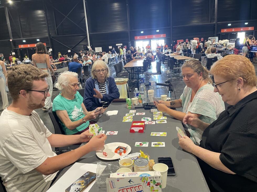 A group of people playing cards at Bordeaux’s exhibition centre on July 27, 2026.