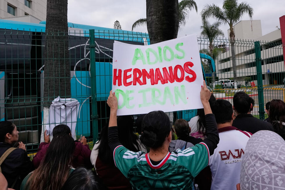 A Mexico fan salutes Iran's "brothers" as the players leave their hotel in Tijuana.