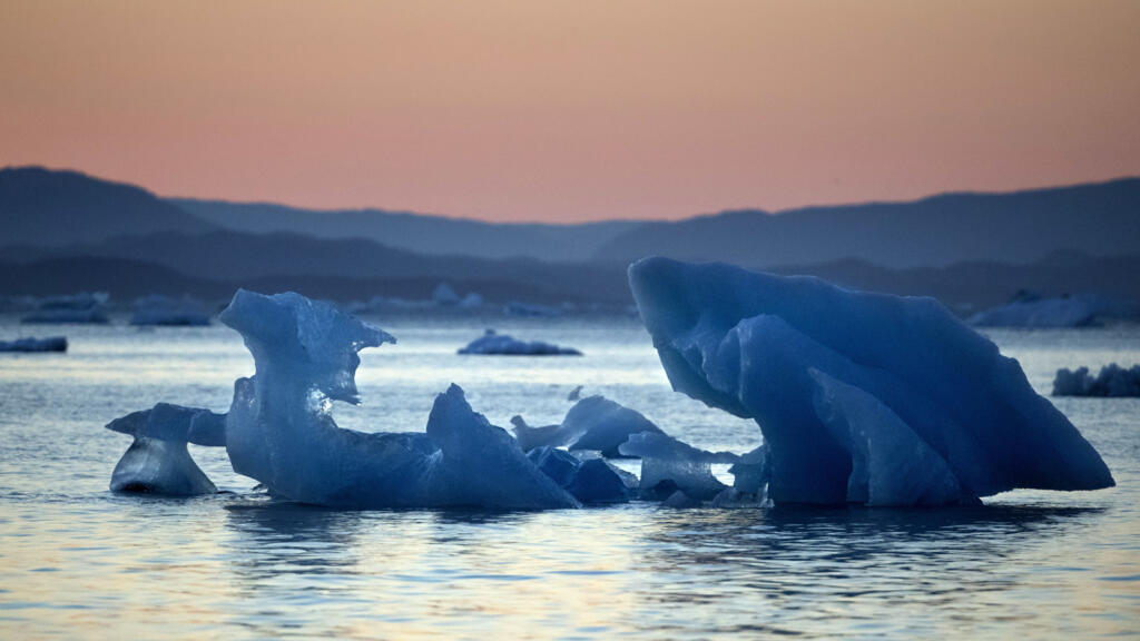 Le soleil se couche alors qu'un iceberg flotte dans le fjord Nuup Kangerlua, près de Nuuk, le 1er août 2017.