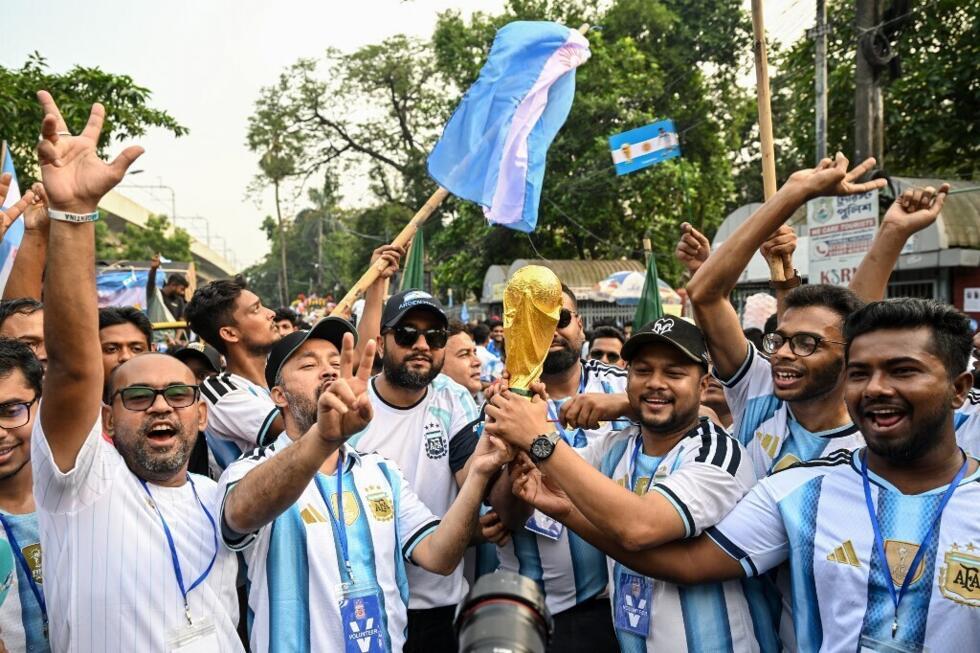 Bangladeshi fans of Argentina carry a World Cup trophy replica in Dhaka on June 16, 2026.