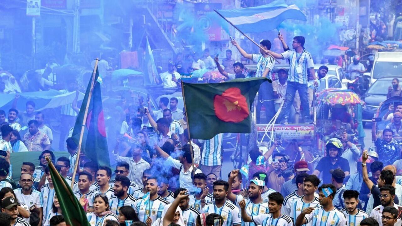 Bangladeshi fans of Argentina carry a World Cup trophy replica in Dhaka on June 16, 2026.