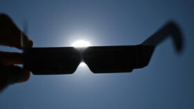 An observer tries eclipse-viewing glasses for direct observation of the sun in Beziers, southern France, on August 5, 2026, ahead of the August 12 eclipse