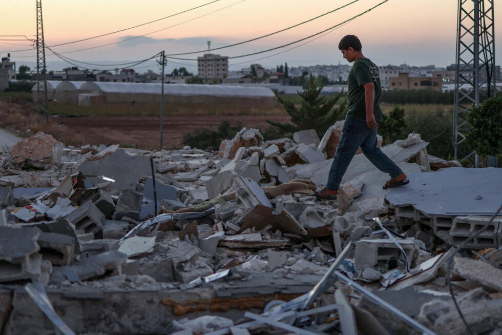 A Palestinian boy inspects the rubble of nearly two dozen shops that were demolished by Israeli bulldozers, citing the lack of a building permit