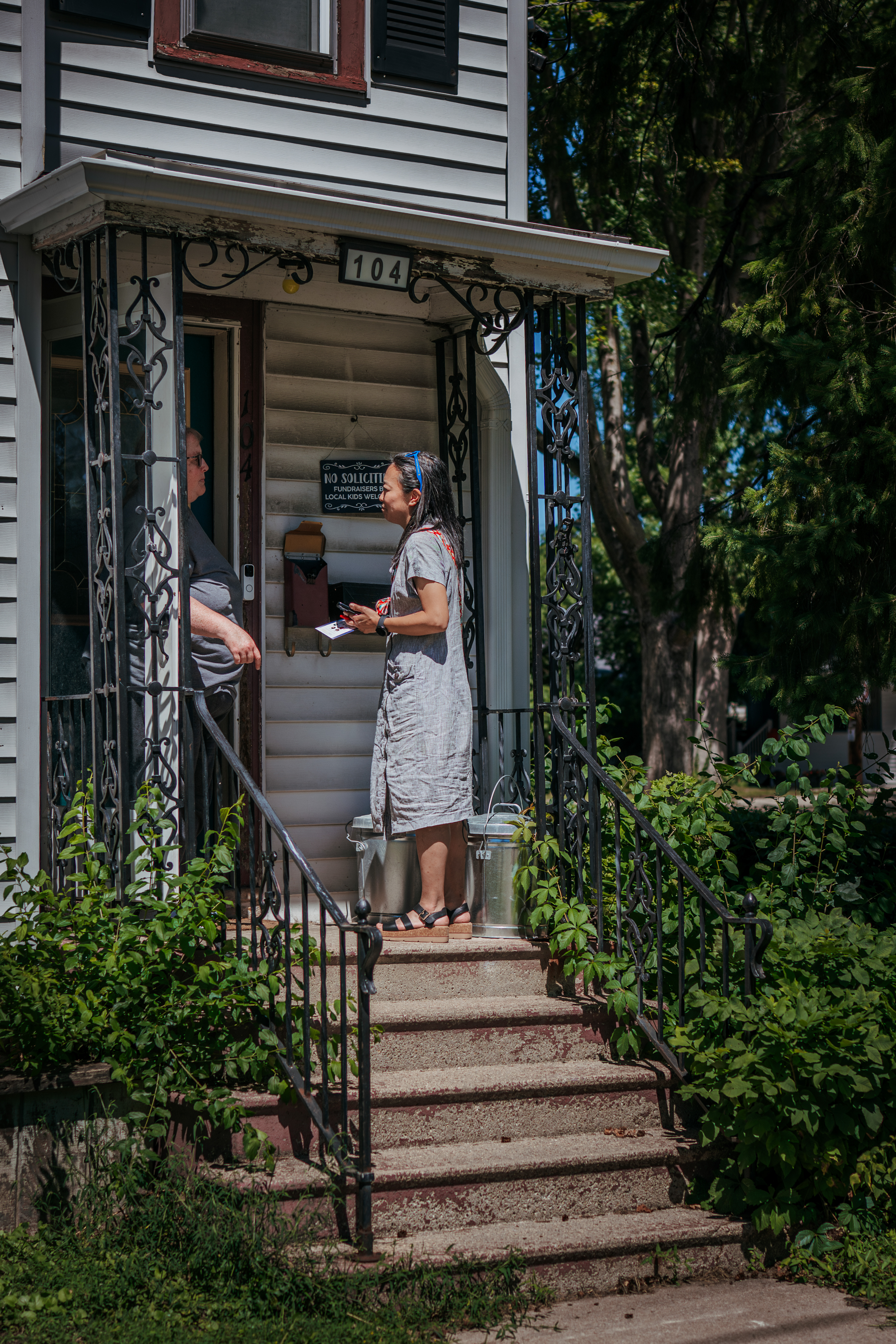 Hong speaks with Heidi Meyer while knocking on doors during a canvassing event in Appleton.
