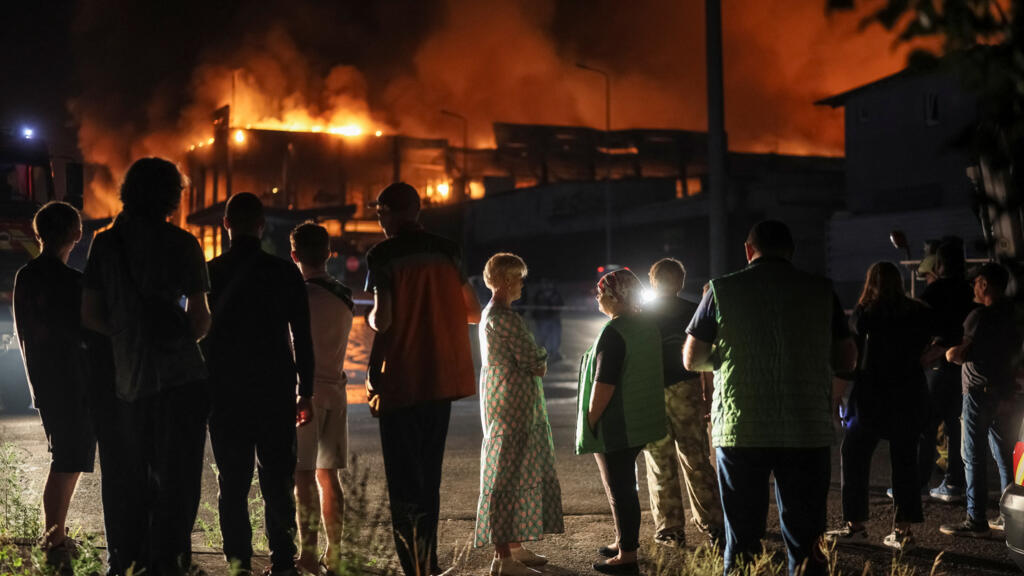 Residents stand at the site of a supermarket warehouse hit by a Russian missile strike in Kyiv, Ukraine.