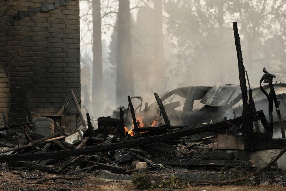 A house on N. Victor St. and W. Lyons Ave. burned by a wildfire smolders,  Aug. 2, 2026, in Spokane, Wash.