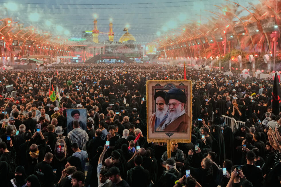Des fidèles chiites, portant un portrait de l'ayatollah Ali Khamenei et de l'ayatollah Khomeini, se rassemblent lors de l'Arbaeen, à Karbala, en Irak.