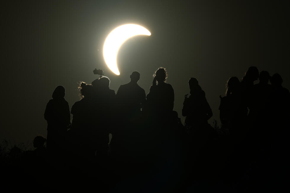 People watch a partial solar eclipse at Northala Fields, London, on 12 August 2026