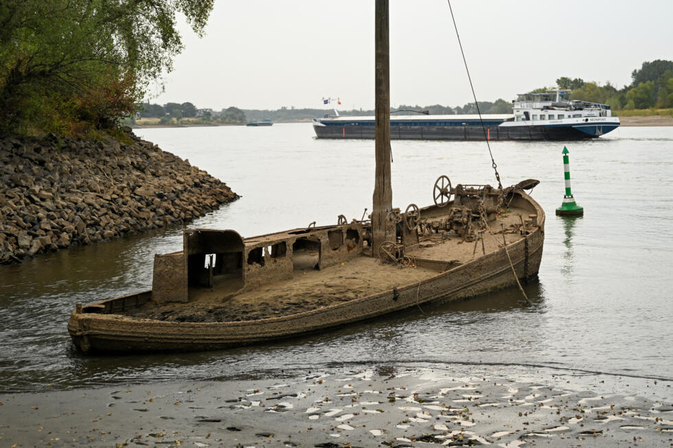 A former eel fishing boat covered in dried mud is seen on low water near the banks of the river Rhine near Neuss, western Germany, on July 30, 2026